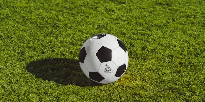 Soccer player celebrating a goal during a night match under stadium lights